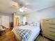 Bedroom features wood floors, ceiling fan, comfortable bed with soft pillows, and en-suite bathroom access at 8130 Bugle Ct # 3, Port Richey, FL 34668