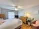 Cozy bedroom features wood floors, ceiling fan, dresser, and a comfortable bed with soft pillows and a plaid throw at 8130 Bugle Ct # 3, Port Richey, FL 34668