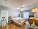 Well-lit bedroom features wood floors, a ceiling fan, a comfortable bed, and a dresser with a lamp at 8130 Bugle Ct # 3, Port Richey, FL 34668