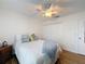 Light bedroom with a ceiling fan, wood-look floors and neutral paint at 8130 Bugle Ct # 3, Port Richey, FL 34668