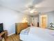 Bedroom with hardwood floors and en-suite bathroom features a comfortable bed, dresser, and window at 8130 Bugle Ct # 3, Port Richey, FL 34668