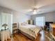 Bright bedroom with wood floors, ceiling fan, bed with plaid throw, and windows with sheer curtains at 8130 Bugle Ct # 3, Port Richey, FL 34668