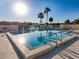 Relaxing community pool with clear water and palm trees under a bright blue sky at 8130 Bugle Ct # 3, Port Richey, FL 34668