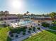 Elevated angle of community pool, sun umbrella, lounge chairs, cabana, and green space at 8130 Bugle Ct # 3, Port Richey, FL 34668