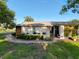 Charming home with decorative wall features, outdoor seating, and lush landscaping at 8130 Bugle Ct # 3, Port Richey, FL 34668
