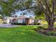 Charming single-story home boasts a lush lawn, manicured landscaping, and mature tree providing ample shade at 8130 Bugle Ct # 3, Port Richey, FL 34668