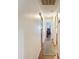 Long hallway with hardwood floors and white walls leading to other rooms of the house at 8130 Bugle Ct # 3, Port Richey, FL 34668