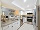 Bright kitchen featuring stainless steel appliances, granite countertops, white cabinets, and tile flooring at 8130 Bugle Ct # 3, Port Richey, FL 34668