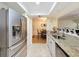 Stainless steel refrigerator with granite countertop and stainless steel sink, with dining area beyond at 8130 Bugle Ct # 3, Port Richey, FL 34668
