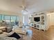 Bright living room with ceiling fan, wood floors, and sliding doors to the sunroom at 8130 Bugle Ct # 3, Port Richey, FL 34668