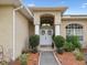 Inviting front entrance with double doors, decorative wreaths, manicured landscaping, and a tiled walkway at 8324 Nightingale Rd, Weeki Wachee, FL 34613