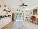 Cozy living room featuring tile floors, a ceiling fan, and sliding doors that offer backyard views at 8324 Nightingale Rd, Weeki Wachee, FL 34613