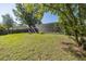 Backyard featuring a screened-in pool and lush, mature shade trees at 9195 Bay Dr, Spring Hill, FL 34608