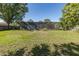 Expansive backyard featuring a screened-in pool enclosure and lush greenery at 9195 Bay Dr, Spring Hill, FL 34608