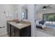 This bathroom boasts a double vanity with granite countertops, complemented by a mirror and an open doorway to the bedroom and porch at 9195 Bay Dr, Spring Hill, FL 34608