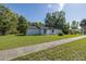 Well-kept single-story home with lush green lawn and mature trees under a blue sky at 9195 Bay Dr, Spring Hill, FL 34608