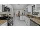 View of open kitchen with stainless steel appliances and granite countertops leading to dining area at 9195 Bay Dr, Spring Hill, FL 34608