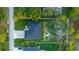 Aerial view of a modern home with a dark roof, showcasing a well-manicured lawn and private fenced-in backyard at 9201 Nightingale Rd, Weeki Wachee, FL 34613
