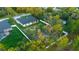 An aerial view highlighting a spacious, green backyard, bordered by a white fence, next to the modern white home at 9201 Nightingale Rd, Weeki Wachee, FL 34613