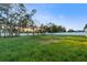 Spacious backyard featuring lush grass, privacy fence, and mature trees creates a private oasis at 9201 Nightingale Rd, Weeki Wachee, FL 34613