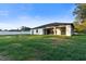 Backyard view featuring a covered patio and outdoor kitchen with a large yard with privacy fence at 9201 Nightingale Rd, Weeki Wachee, FL 34613