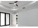 Bedroom features a modern ceiling fan, white walls, a closet, and a black framed glass door at 9201 Nightingale Rd, Weeki Wachee, FL 34613