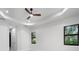 Spacious bedroom with a tray ceiling, large windows, and modern ceiling fan at 9201 Nightingale Rd, Weeki Wachee, FL 34613