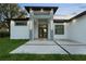 Elegant home entrance featuring stylish lighting, modern design, and a well-maintained lawn at 9201 Nightingale Rd, Weeki Wachee, FL 34613