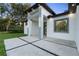 Elegant home entrance featuring stylish lighting, modern design, and a well-maintained lawn at 9201 Nightingale Rd, Weeki Wachee, FL 34613