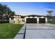 Stunning contemporary home featuring a manicured lawn, wide driveway, and a stylish two-car garage at 9201 Nightingale Rd, Weeki Wachee, FL 34613