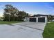 Contemporary home featuring a spacious driveway, well-maintained lawn, and a modern two-car garage at 9201 Nightingale Rd, Weeki Wachee, FL 34613