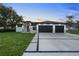 Stunning contemporary home featuring a manicured lawn, wide driveway, and a stylish two-car garage at 9201 Nightingale Rd, Weeki Wachee, FL 34613