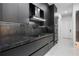 Sleek modern kitchen with stainless steel appliances, black marble backsplash, and custom cabinetry at 9201 Nightingale Rd, Weeki Wachee, FL 34613