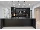 Modern kitchen boasts a large island with black countertops, stylish pendant lights, and sleek black cabinetry at 9201 Nightingale Rd, Weeki Wachee, FL 34613