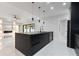 Modern kitchen island, pendant lighting, and open layout flow to living space at 9201 Nightingale Rd, Weeki Wachee, FL 34613