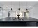 Modern open floor plan featuring a large kitchen island with black countertops and dining area at 9201 Nightingale Rd, Weeki Wachee, FL 34613
