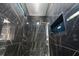 Sleek shower with dark tile, a rainfall showerhead, built in shelving, and glass door at 9201 Nightingale Rd, Weeki Wachee, FL 34613