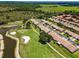 Scenic aerial view of townhomes nestled along a lush green golf course and water feature at 1009 Almondwood Dr, Trinity, FL 34655