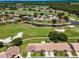 Beautiful aerial view of the community golf course, surrounding ponds, and a few houses with pools at 1009 Almondwood Dr, Trinity, FL 34655
