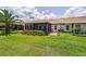 Exterior shot showcasing a well-maintained yard with lush landscaping and patio at 1009 Almondwood Dr, Trinity, FL 34655
