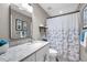 Updated bathroom featuring a granite countertop, modern mirror, and a stylish shower curtain at 1009 Almondwood Dr, Trinity, FL 34655