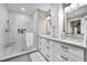 Modern bathroom with double vanity, glass walk-in shower, and neutral accents at 1009 Almondwood Dr, Trinity, FL 34655