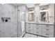 Elegant bathroom features a glass walk-in shower and double vanity with granite countertops at 1009 Almondwood Dr, Trinity, FL 34655