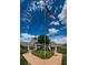 Welcoming clubhouse entrance with brick walkway, manicured landscaping, and an American flag at 1009 Almondwood Dr, Trinity, FL 34655