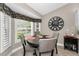 Bright dining area featuring shuttered windows, a round table with chairs, and a decorative wall clock at 1009 Almondwood Dr, Trinity, FL 34655