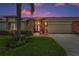 Charming single-story home with a red front door, well-manicured lawn, and an attached two-car garage at 1009 Almondwood Dr, Trinity, FL 34655