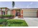 Charming single-story home with a red front door, well-manicured lawn, and an attached two-car garage at 1009 Almondwood Dr, Trinity, FL 34655
