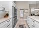 Bright, open kitchen with white cabinets, stainless steel appliances, and luxury vinyl plank flooring at 1009 Almondwood Dr, Trinity, FL 34655