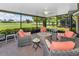 Relaxing screened-in lanai with stylish furniture, ceiling fan, and scenic golf course vistas at 1009 Almondwood Dr, Trinity, FL 34655