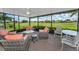 Inviting screened-in lanai with comfortable seating, ceiling fan, and views of the green golf course at 1009 Almondwood Dr, Trinity, FL 34655